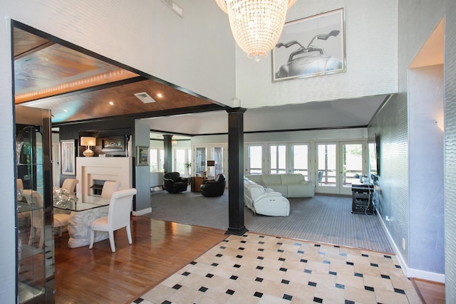 entryway with a healthy amount of sunlight, a towering ceiling, an inviting chandelier, and french doors