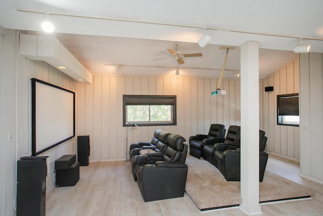 cinema room featuring rail lighting, ceiling fan, and light hardwood / wood-style floors