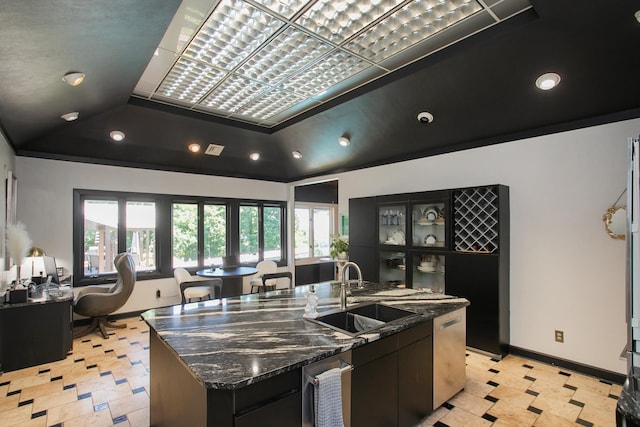 kitchen with sink, a raised ceiling, dishwasher, dark stone counters, and a large island