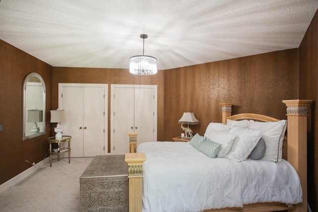 carpeted bedroom with a chandelier and a textured ceiling