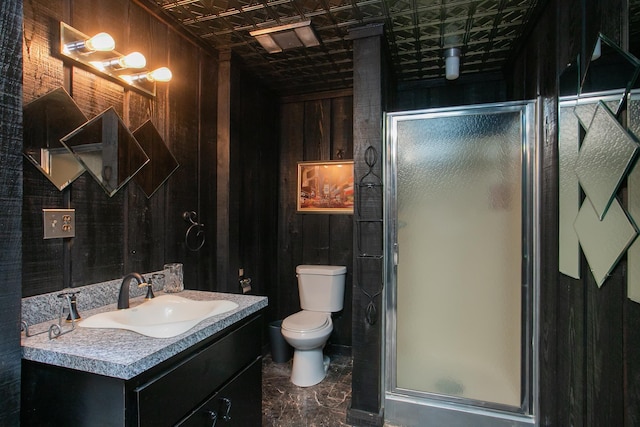 bathroom featuring vanity, toilet, wood walls, and walk in shower