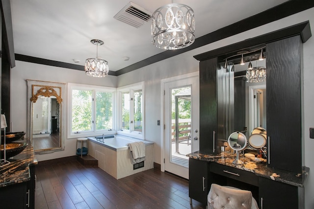 kitchen featuring dark hardwood / wood-style flooring, decorative light fixtures, dark stone countertops, and a chandelier