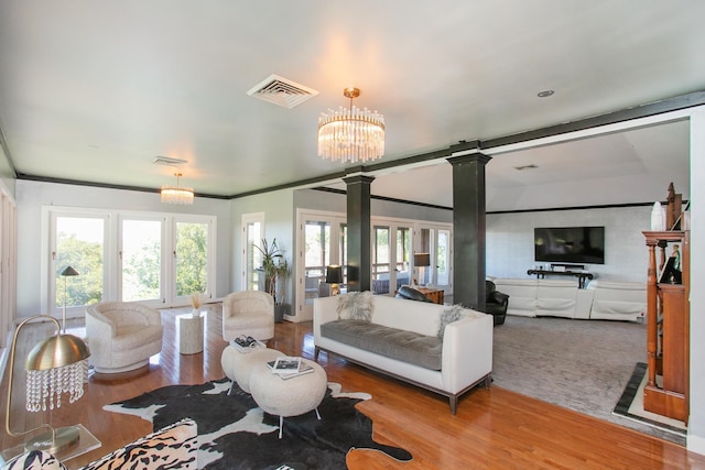 living room with an inviting chandelier, light hardwood / wood-style flooring, and a healthy amount of sunlight