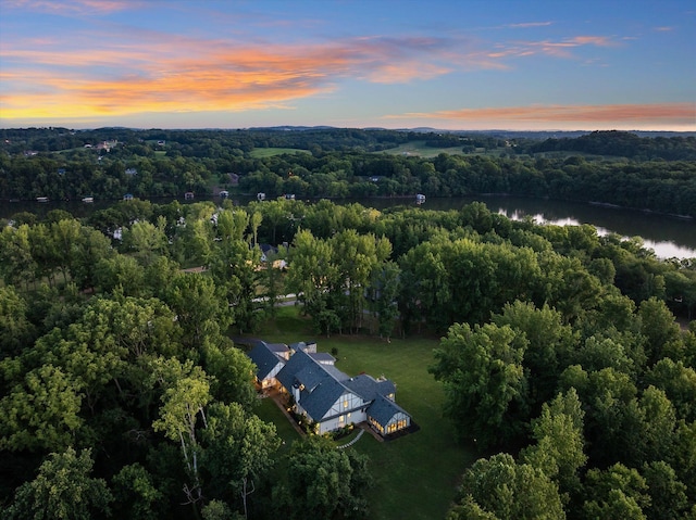 aerial view at dusk featuring a water view