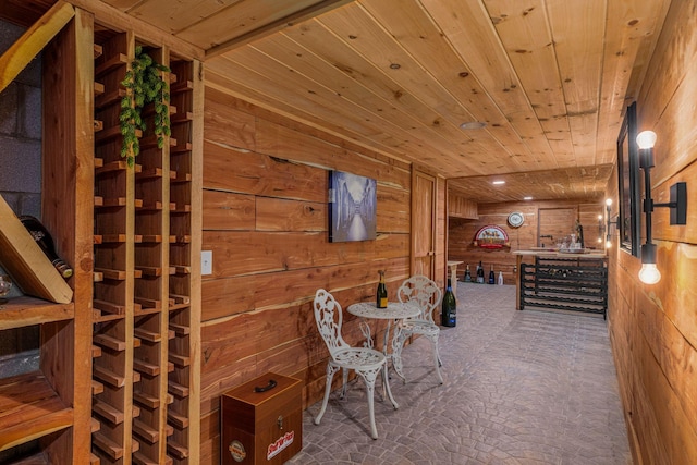 wine room with wood walls and wooden ceiling