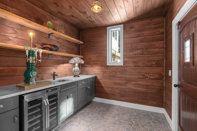 bar with pendant lighting, wine cooler, and wooden walls