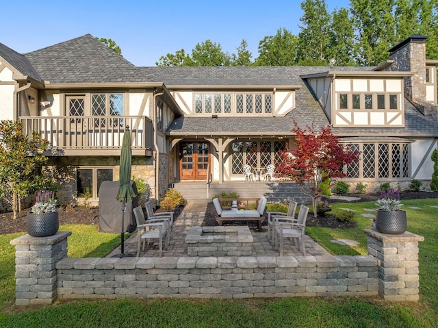 back of property featuring a balcony and a patio