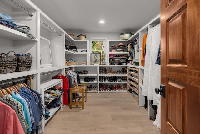 walk in closet with light hardwood / wood-style flooring