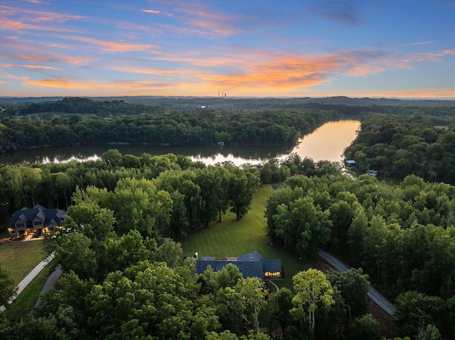 aerial view at dusk featuring a water view