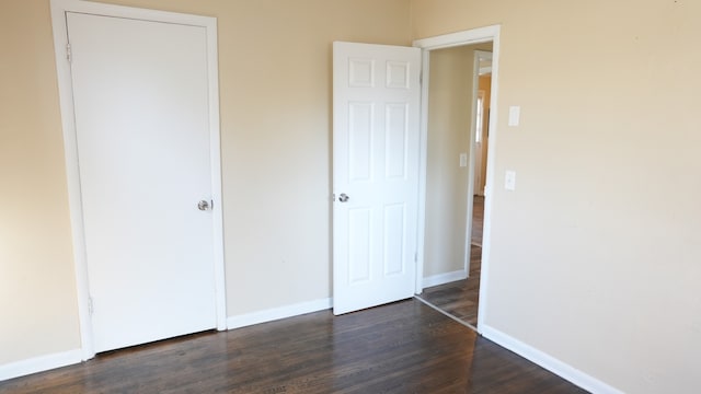 unfurnished bedroom featuring dark hardwood / wood-style flooring and a closet