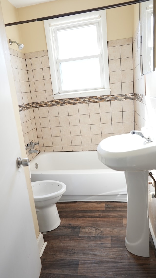 bathroom featuring toilet, tiled shower / bath, and hardwood / wood-style floors