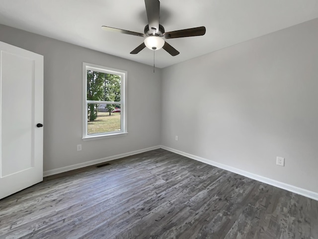 empty room with dark hardwood / wood-style flooring and ceiling fan