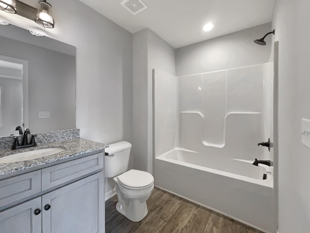 full bathroom featuring bathing tub / shower combination, hardwood / wood-style floors, vanity, and toilet