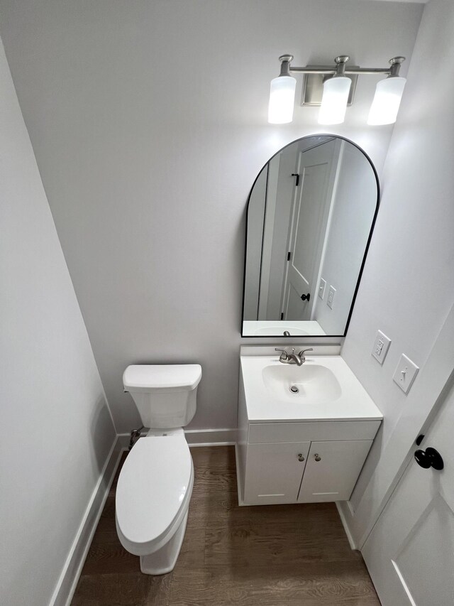 bathroom featuring hardwood / wood-style flooring, toilet, and vanity