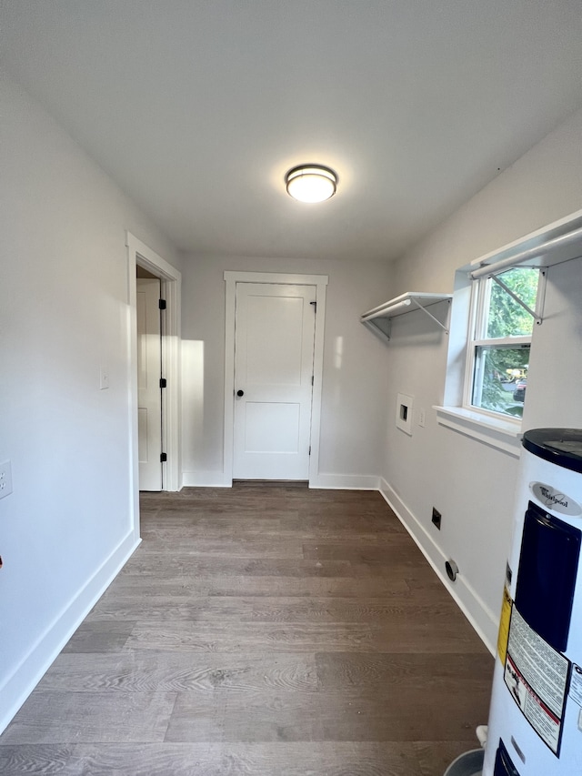 interior space featuring electric water heater, hookup for a washing machine, and hardwood / wood-style floors