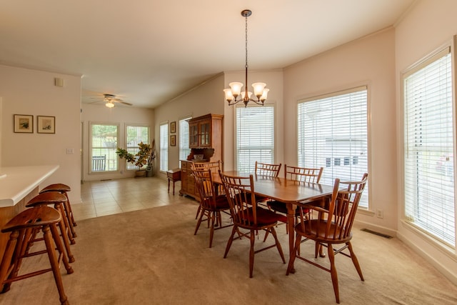 dining space with ceiling fan with notable chandelier, light colored carpet, and a wealth of natural light