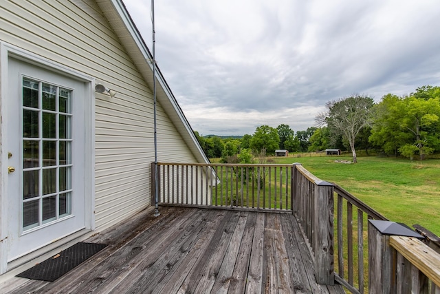 wooden terrace featuring a lawn