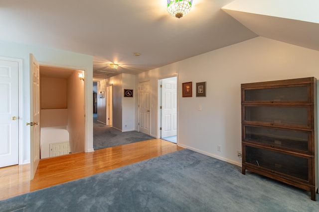 spare room with dark hardwood / wood-style floors and lofted ceiling