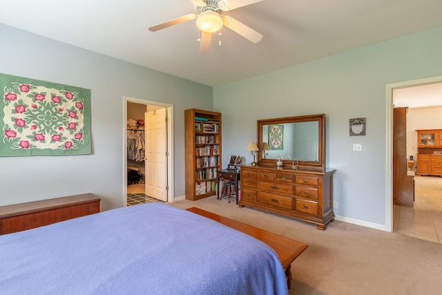 tiled bedroom with ceiling fan, a walk in closet, and a closet