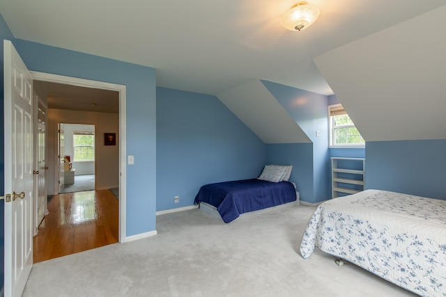 carpeted bedroom with lofted ceiling