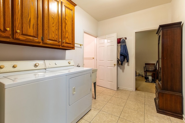 washroom featuring light tile patterned flooring, separate washer and dryer, and cabinets