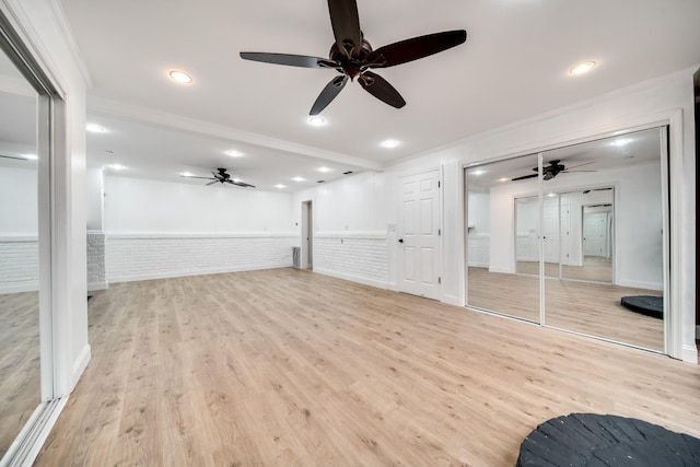 unfurnished living room with brick wall, ceiling fan, light hardwood / wood-style floors, crown molding, and beam ceiling