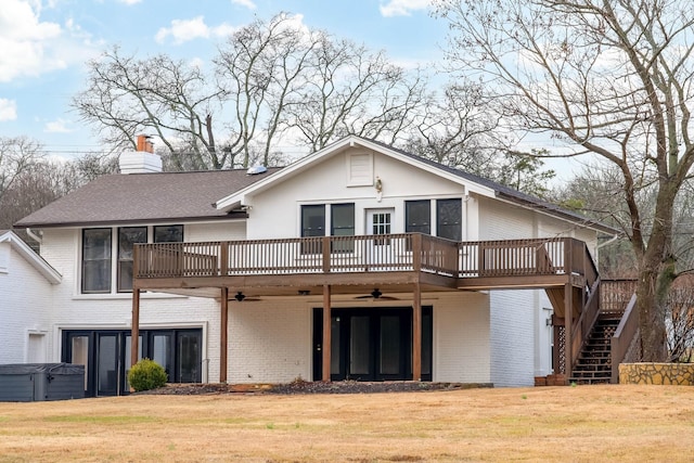 rear view of property featuring a yard, a hot tub, ceiling fan, and a deck