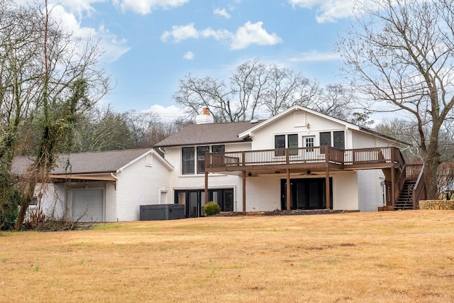 back of property featuring a wooden deck and a lawn