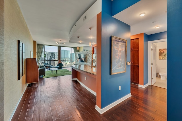 hallway featuring dark hardwood / wood-style floors, sink, and a wall of windows