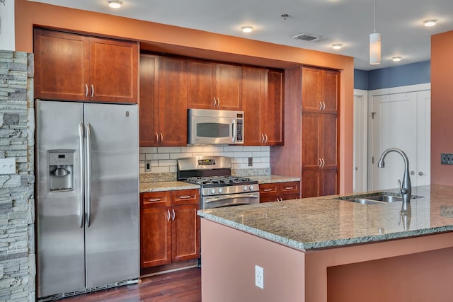 kitchen with appliances with stainless steel finishes, sink, backsplash, decorative light fixtures, and dark wood-type flooring