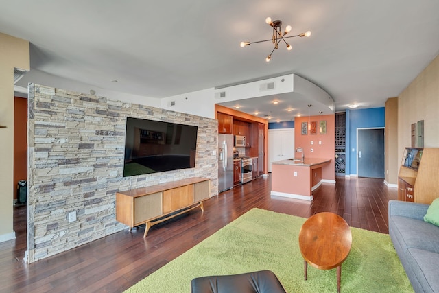 living room featuring sink, a chandelier, and dark hardwood / wood-style floors