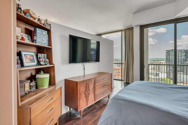 bedroom featuring a wall of windows, dark hardwood / wood-style flooring, and access to exterior