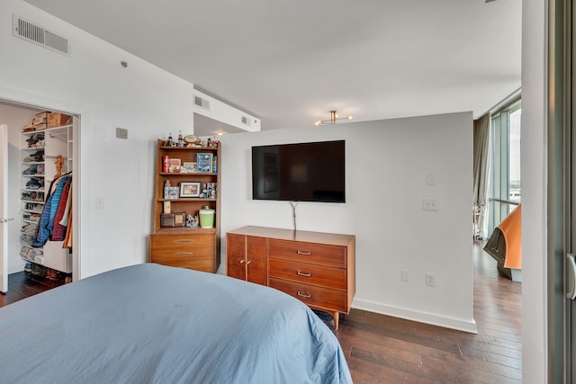 bedroom featuring dark hardwood / wood-style flooring, a closet, and a walk in closet