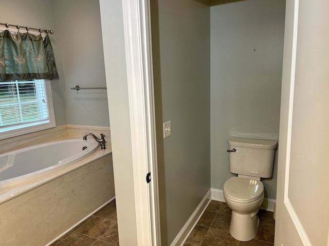 bathroom featuring tile patterned floors, a bath, and toilet