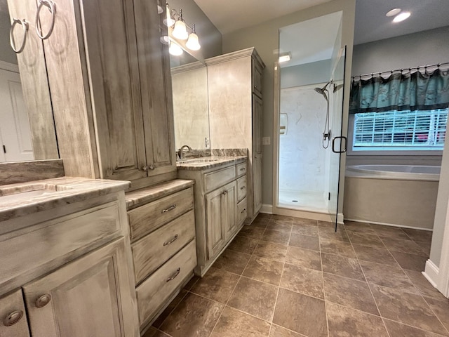 bathroom with a garden tub, a sink, two vanities, baseboards, and a shower stall