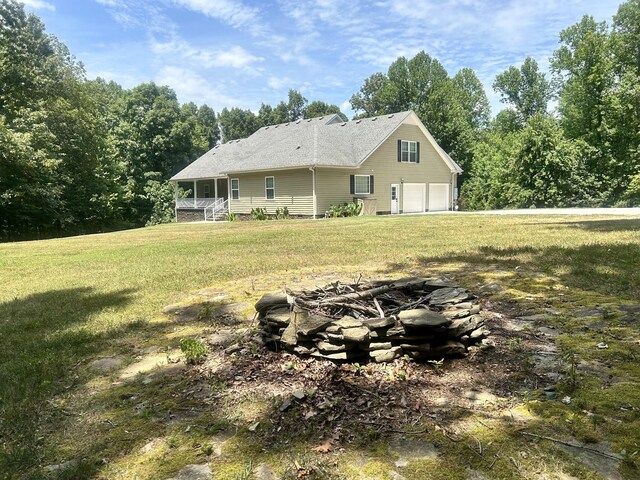 back of property with a garage and a lawn