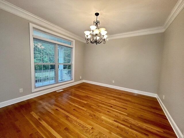 unfurnished room featuring a chandelier, hardwood / wood-style flooring, and ornamental molding