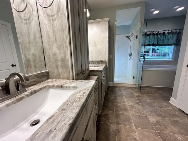 full bath featuring a bath, a stall shower, vanity, and baseboards
