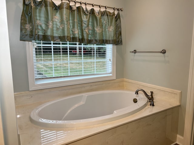 bathroom featuring a bathing tub and a wealth of natural light