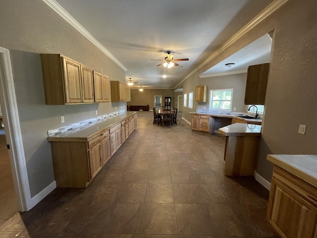 kitchen featuring kitchen peninsula, tile patterned floors, ornamental molding, ceiling fan, and sink