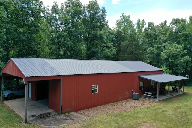 view of outbuilding featuring central AC and a lawn