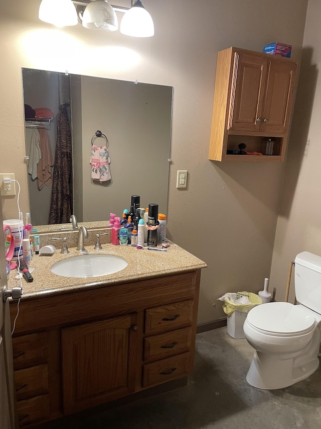 bathroom featuring vanity, toilet, and concrete flooring