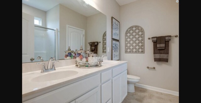 bathroom featuring vanity, toilet, and a shower with door