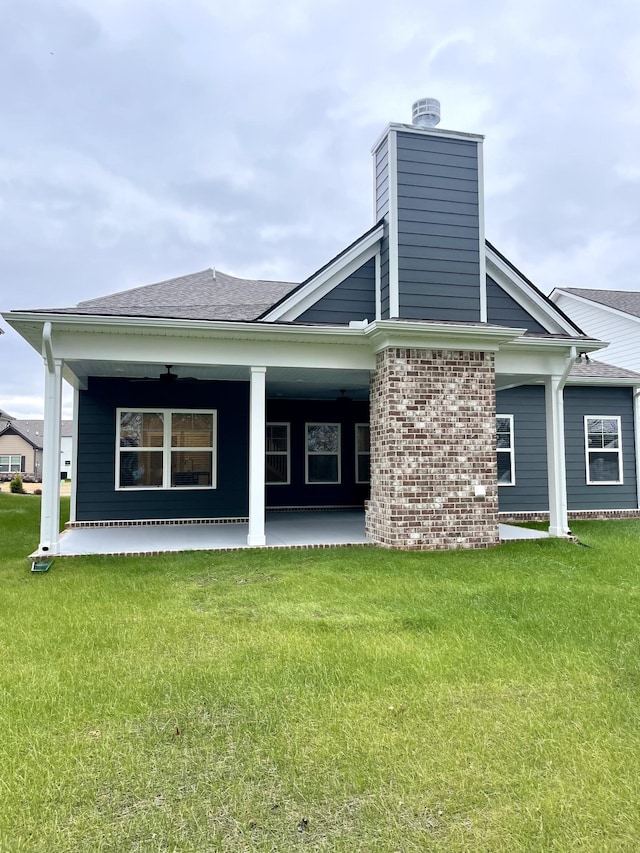 rear view of house with a patio area and a lawn