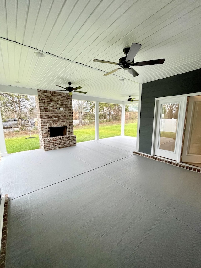 view of patio with an outdoor brick fireplace and ceiling fan