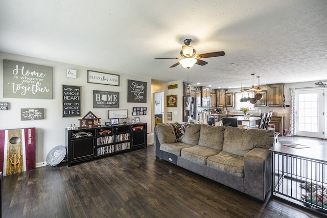 living room with wood-type flooring, a textured ceiling, and ceiling fan