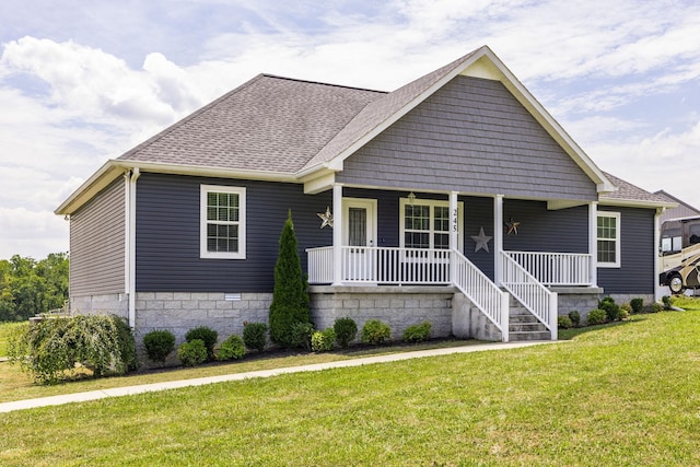 view of front of home with a porch, a front lawn, and a shingled roof