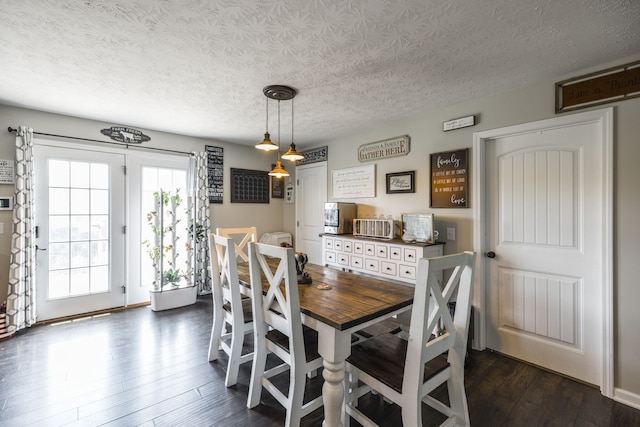 dining area featuring a textured ceiling and dark hardwood / wood-style flooring