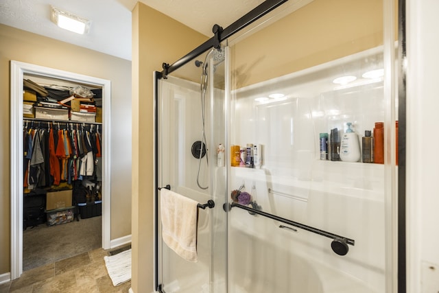 bathroom with a shower with shower door and tile patterned floors