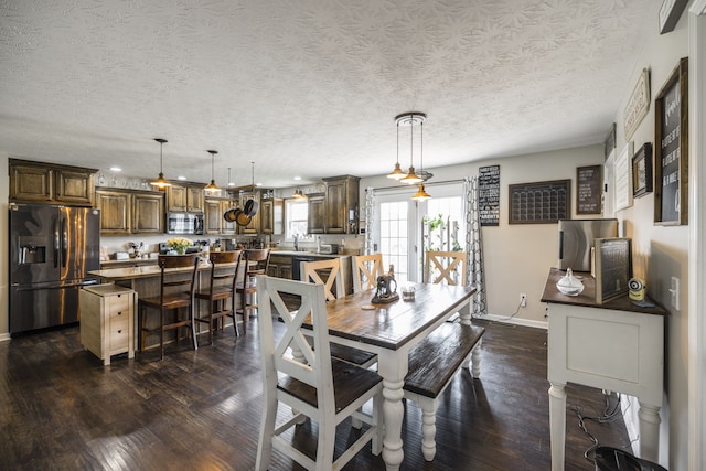 dining room with sink, dark hardwood / wood-style floors, and a textured ceiling